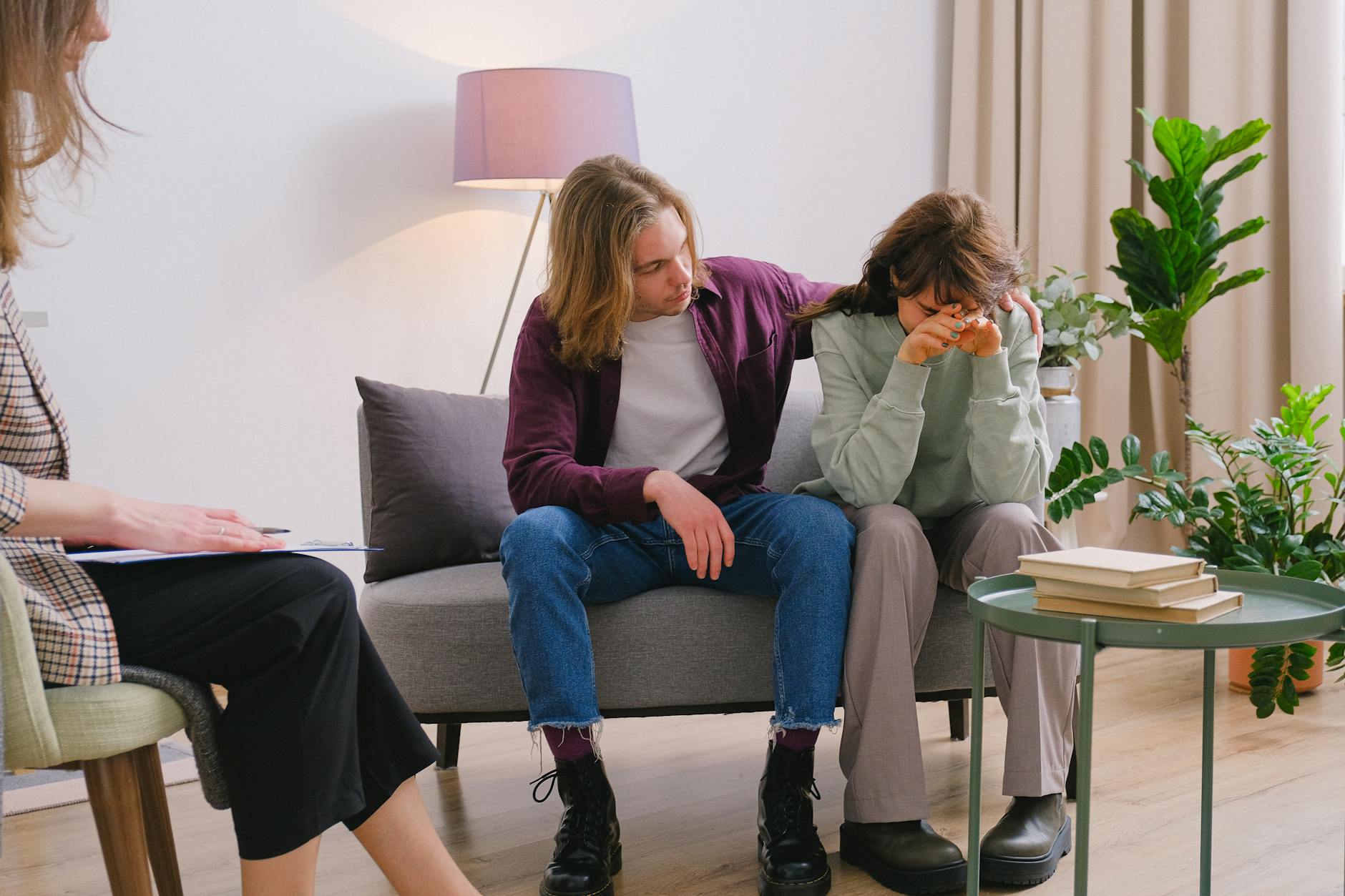 Mężczyzna obejmuje zdenerwowaną partnerkę podczas sesji u psychologa