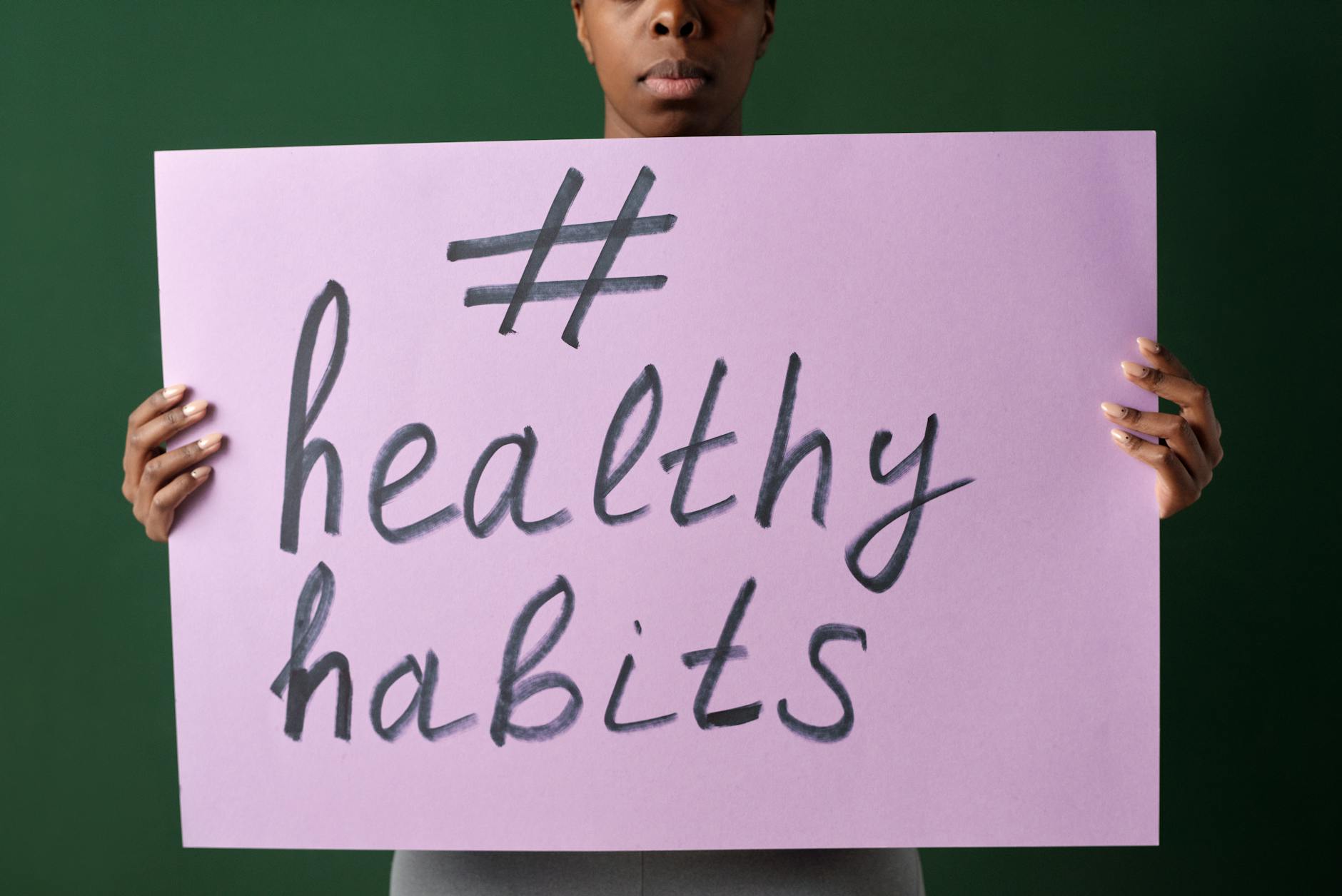 Osoba trzyma kartkę z napisem #healthyhabits promującą codzienne nawyki