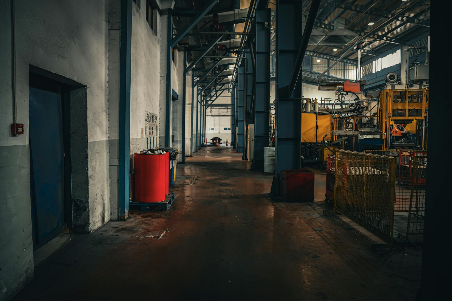 Pusta hala produkcyjna z maszynami i industrialnym oświetleniem